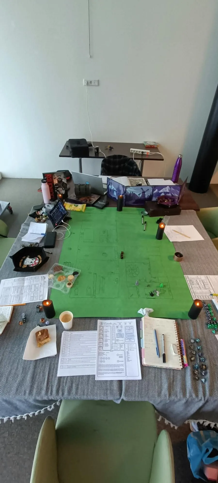 Een tafel met een kaart, dobbelstenen, notities en kaarsen voor een D&D-avond